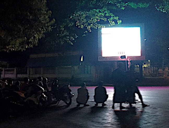Locals stopped at a street side screen posting election results. 