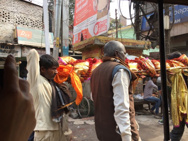 Family members carrying the body toward the fire.